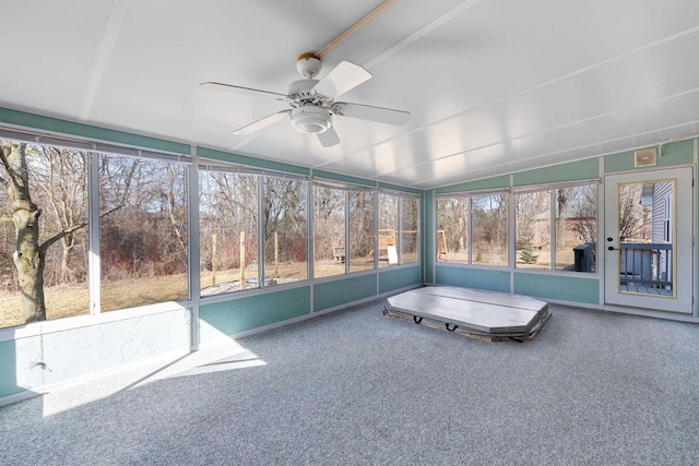 unfurnished sunroom featuring a ceiling fan and vaulted ceiling