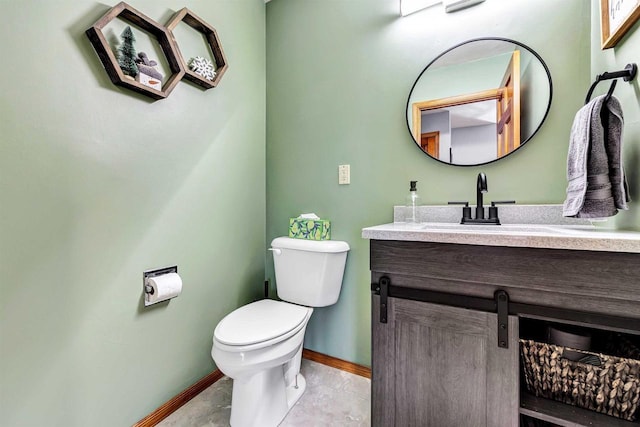 half bathroom featuring toilet, vanity, and baseboards