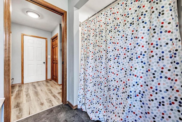 full bathroom featuring curtained shower and baseboards