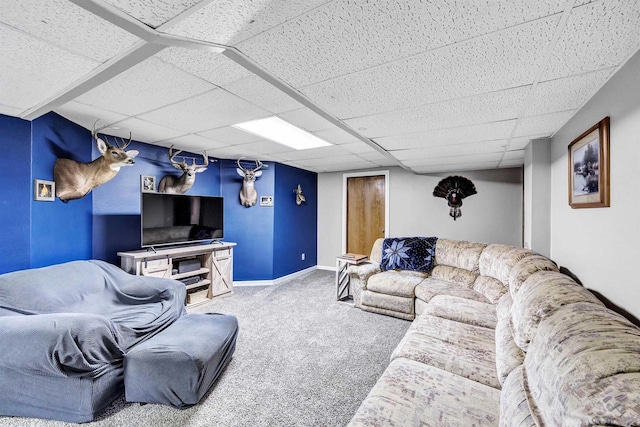 carpeted living room featuring a drop ceiling and baseboards