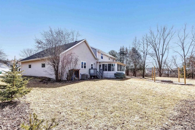 back of property with a yard, central AC, and a sunroom