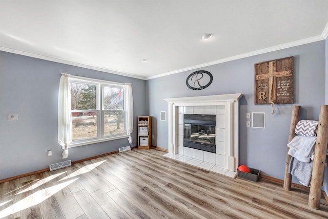 unfurnished living room with visible vents, crown molding, baseboards, and wood finished floors