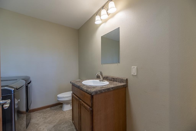 5628 E Eagle Dr, Milton, WI 53563 - half bath featuring washer and clothes dryer, toilet, vanity, and baseboards