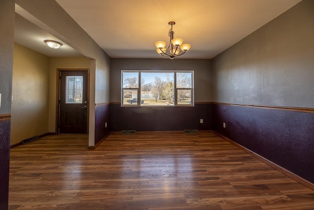 5628 E Eagle Dr, Milton, WI 53563 - unfurnished dining area featuring dark wood finished floors, a notable chandelier, baseboards, and visible vents