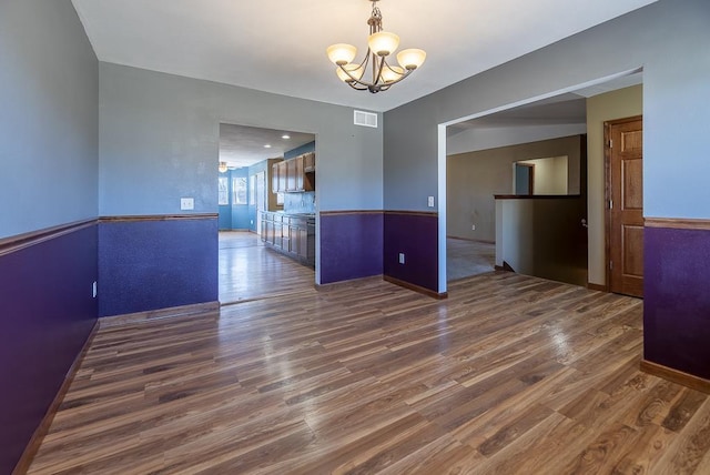 5628 E Eagle Dr, Milton, WI 53563 - empty room with an inviting chandelier, dark wood-style floors, and visible vents