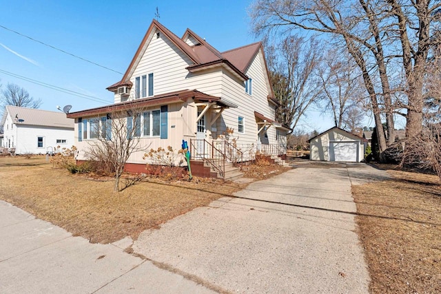 view of front of house featuring an outbuilding, driveway, and a detached garage