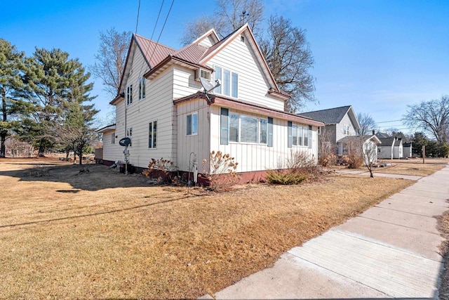 view of side of home with a lawn and board and batten siding