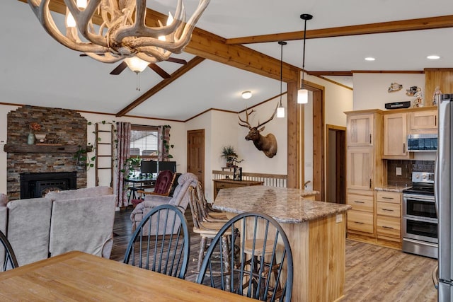 kitchen with light wood-style flooring, light brown cabinets, stainless steel appliances, ceiling fan, and vaulted ceiling with beams