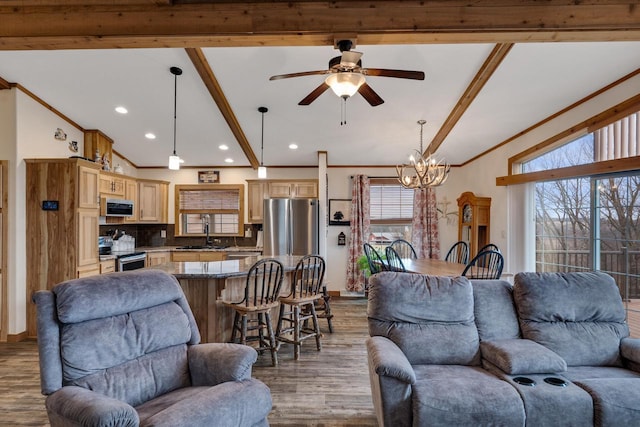 living area featuring ceiling fan with notable chandelier, wood finished floors, recessed lighting, crown molding, and vaulted ceiling with beams