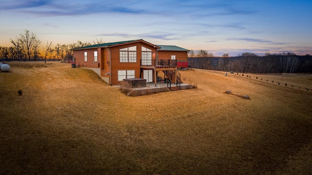 rear view of property featuring stairs, a deck, and a patio area