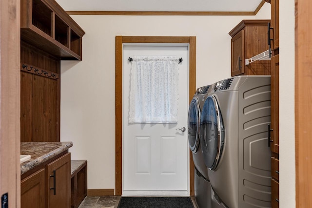 laundry room featuring baseboards, cabinet space, washing machine and dryer, and ornamental molding