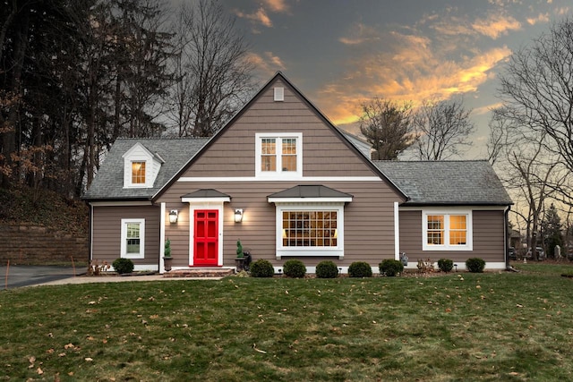 view of front of home featuring a front lawn and roof with shingles