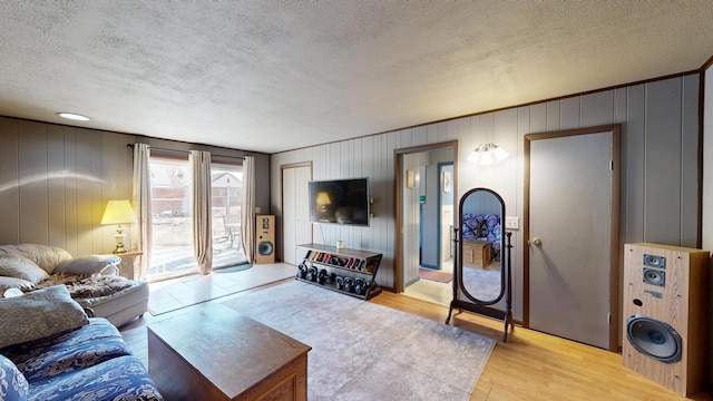 living area featuring light wood-type flooring and a textured ceiling