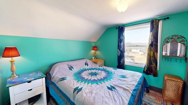 bedroom with vaulted ceiling and baseboards