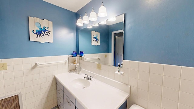 bathroom featuring vanity, tile walls, and wainscoting