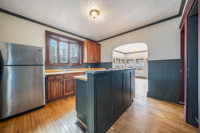 kitchen featuring visible vents, an ornate ceiling, ornamental molding, freestanding refrigerator, and a sink