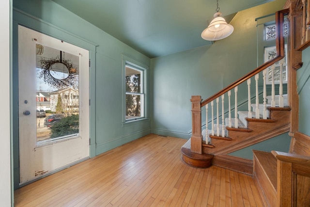 entrance foyer with stairs, hardwood / wood-style flooring, and baseboards