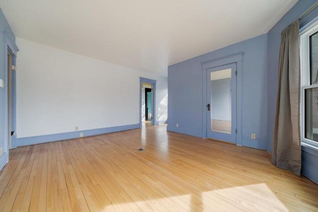 spare room with light wood finished floors and baseboards