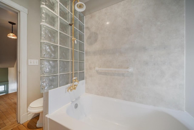 full bathroom featuring toilet, a tub, walk in shower, and wood finished floors