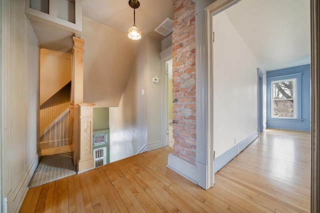 additional living space with stairway, baseboards, visible vents, and wood-type flooring