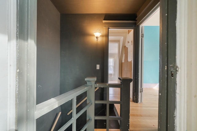 hallway featuring an upstairs landing and wood finished floors