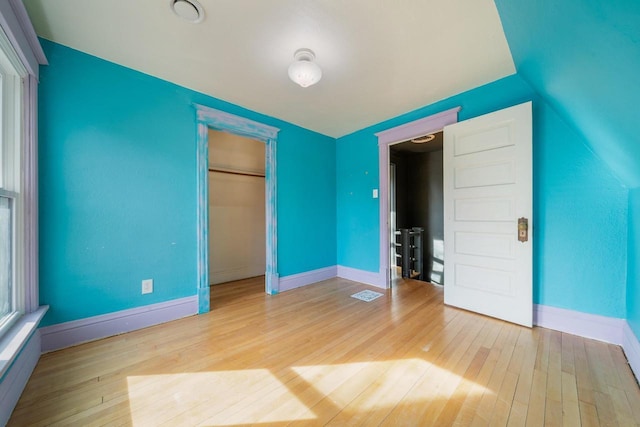 unfurnished bedroom with a closet, baseboards, and hardwood / wood-style flooring