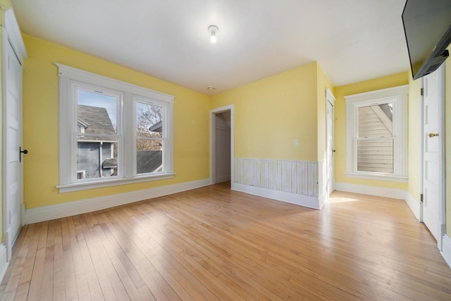 empty room featuring baseboards and light wood-style flooring