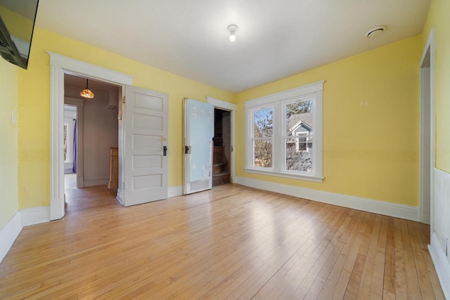 empty room with baseboards and light wood finished floors