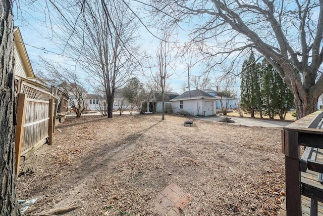 view of yard with fence and an outdoor fire pit