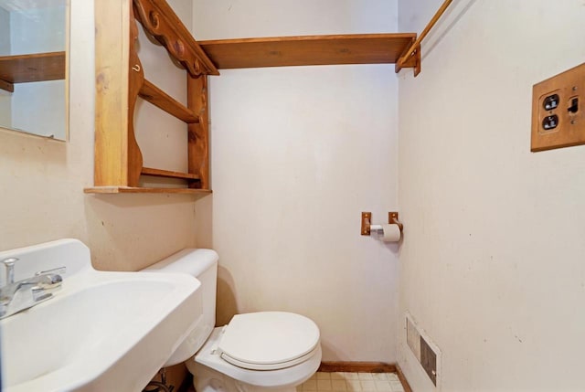 half bath featuring a sink, visible vents, and toilet