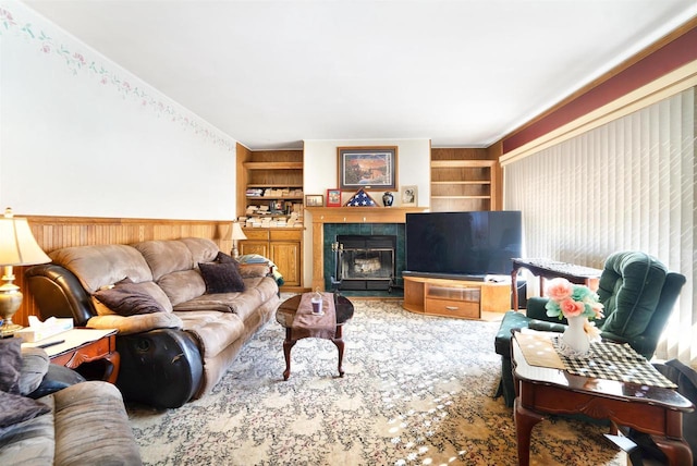 living area featuring a tile fireplace and built in shelves