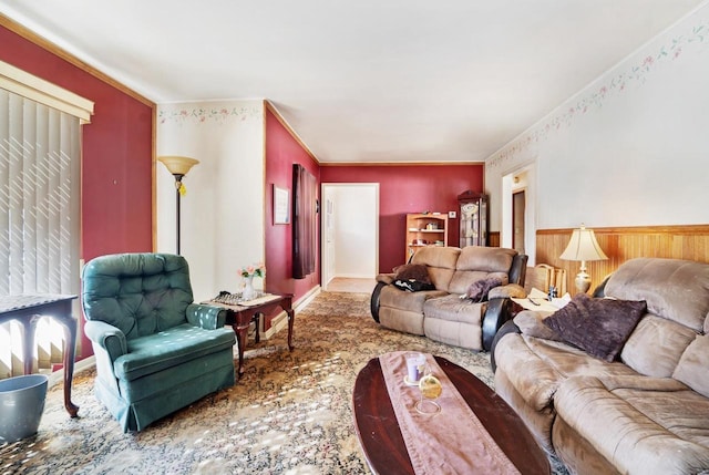 living area with wainscoting, baseboards, and ornamental molding