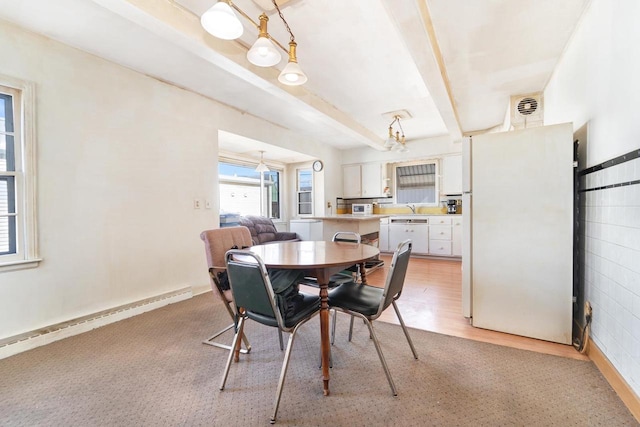 dining room featuring visible vents, baseboards, beamed ceiling, light wood-type flooring, and baseboard heating