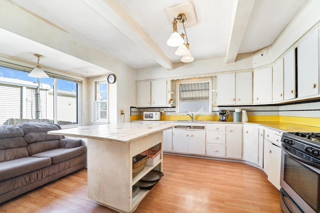 kitchen featuring gas stove, open shelves, light wood-style flooring, beam ceiling, and white cabinets