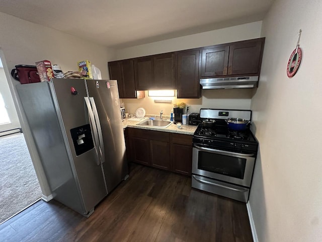 kitchen with dark wood-type flooring, under cabinet range hood, a sink, stainless steel appliances, and dark brown cabinetry