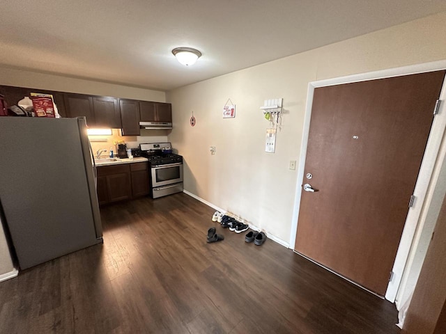 kitchen featuring under cabinet range hood, light countertops, dark wood-style floors, stainless steel appliances, and a sink