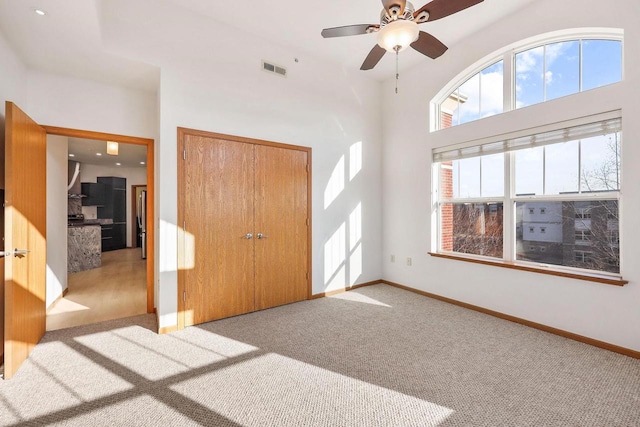 entryway with visible vents, baseboards, ceiling fan, and carpet flooring