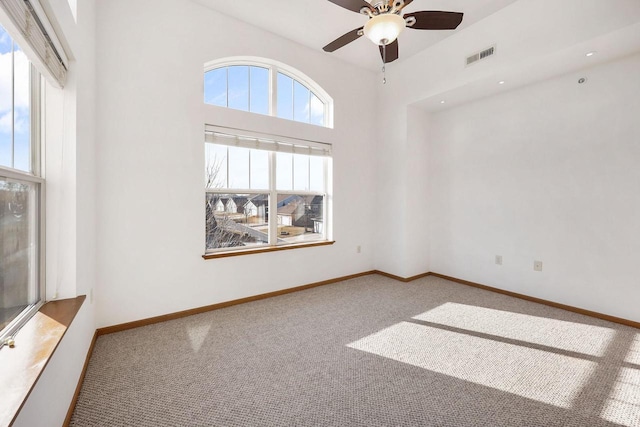 carpeted spare room featuring a ceiling fan, baseboards, and visible vents