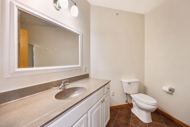 bathroom with tile patterned floors, baseboards, toilet, and vanity