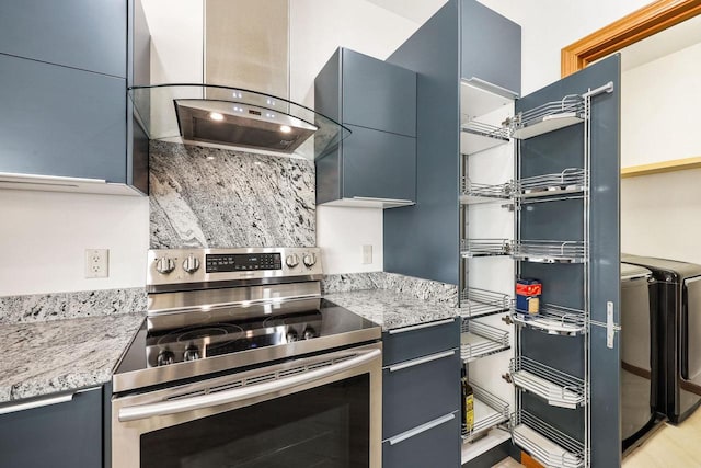 kitchen with light stone countertops, island exhaust hood, stainless steel range with electric stovetop, modern cabinets, and independent washer and dryer