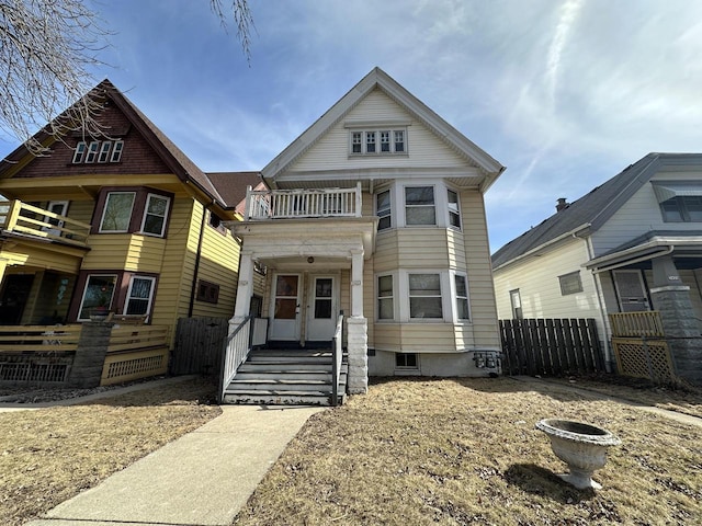 view of front of house with a balcony and fence