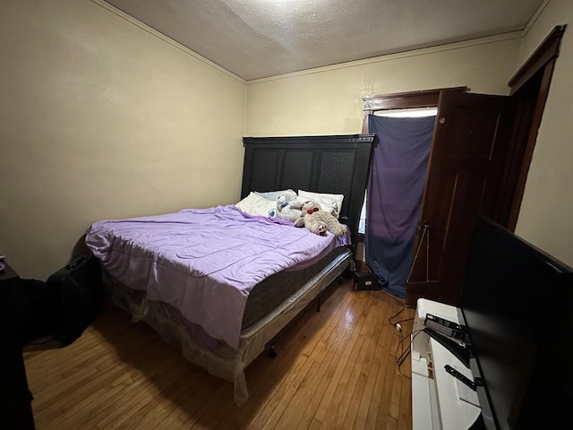 bedroom featuring hardwood / wood-style floors and a textured ceiling