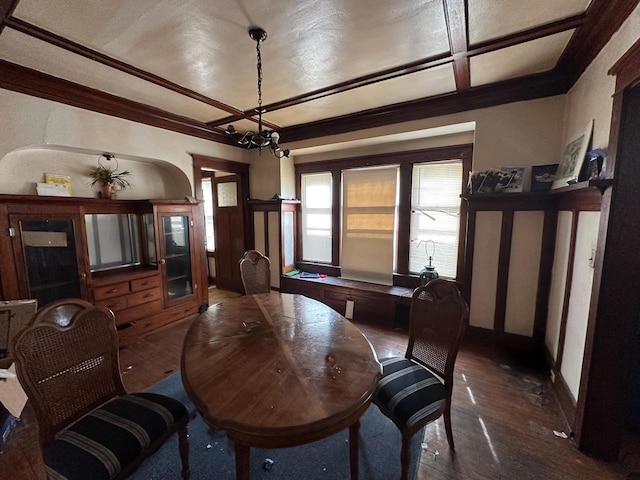 dining space featuring crown molding, baseboards, an inviting chandelier, hardwood / wood-style flooring, and coffered ceiling