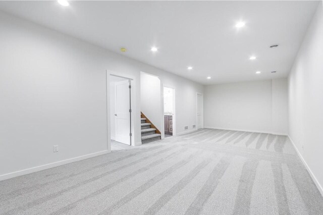 spare room featuring stairway, recessed lighting, and baseboards