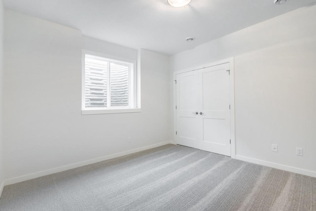 unfurnished bedroom with a closet, baseboards, and carpet floors