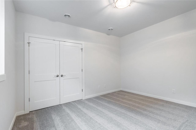 unfurnished bedroom featuring a closet, baseboards, and carpet floors