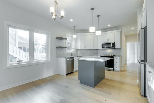 kitchen featuring light wood-style flooring, open shelves, a kitchen island, tasteful backsplash, and stainless steel appliances