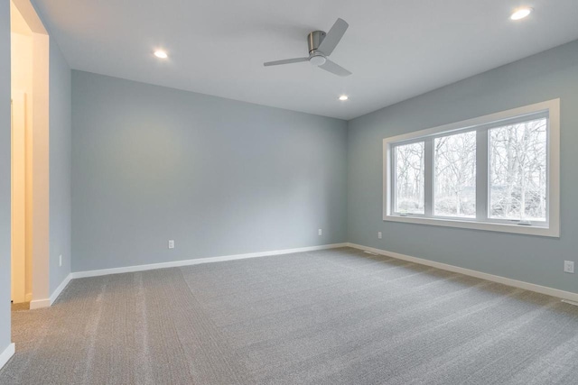 carpeted spare room featuring recessed lighting, baseboards, and a ceiling fan