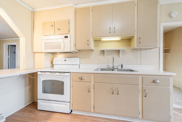 kitchen with white appliances, crown molding, light countertops, and a sink