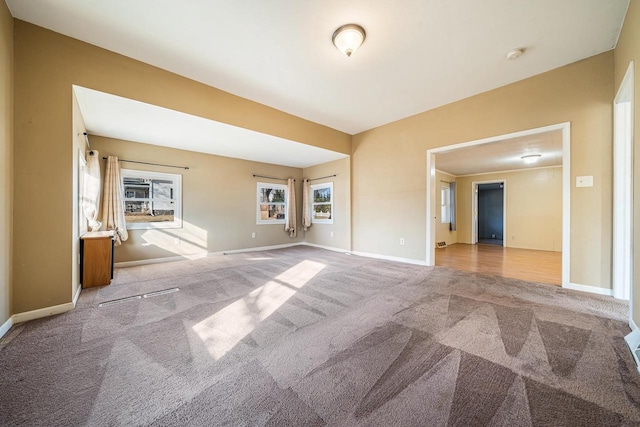 spare room featuring carpet flooring and baseboards